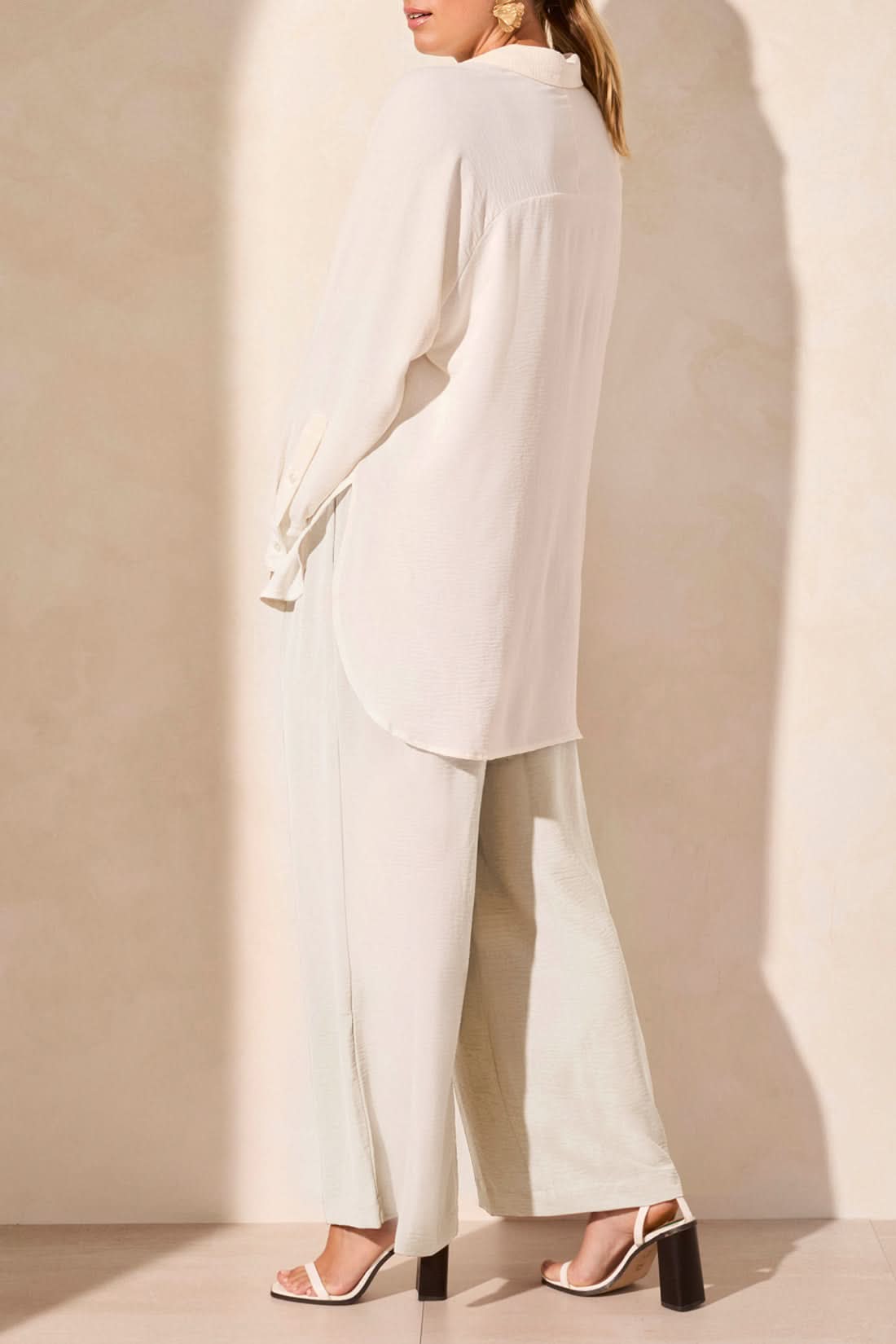 A person wearing the Tribal FLOWY RAGLAN SLEEVE SHIRT in brown, paired with loose-fitting pants, stands against a plain light-colored background.