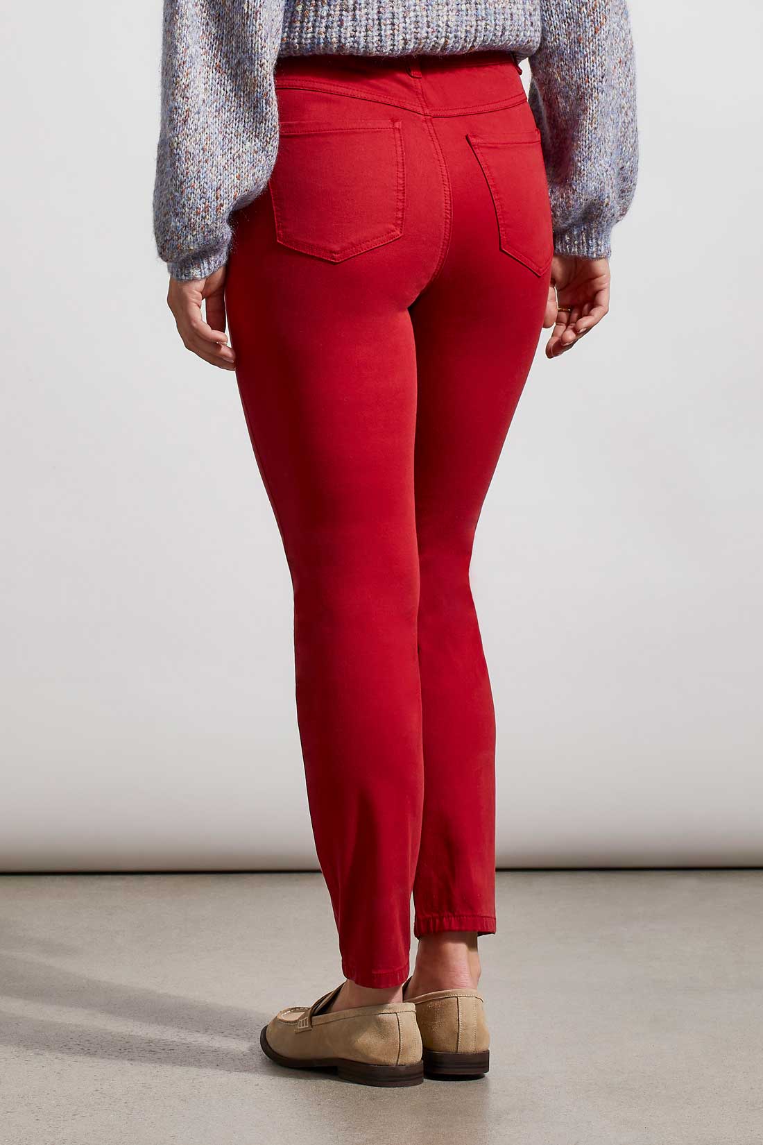 A woman wearing red Tribal Audrey Icon Pull On skinny jeans and a blue sweater with a flattering fit.