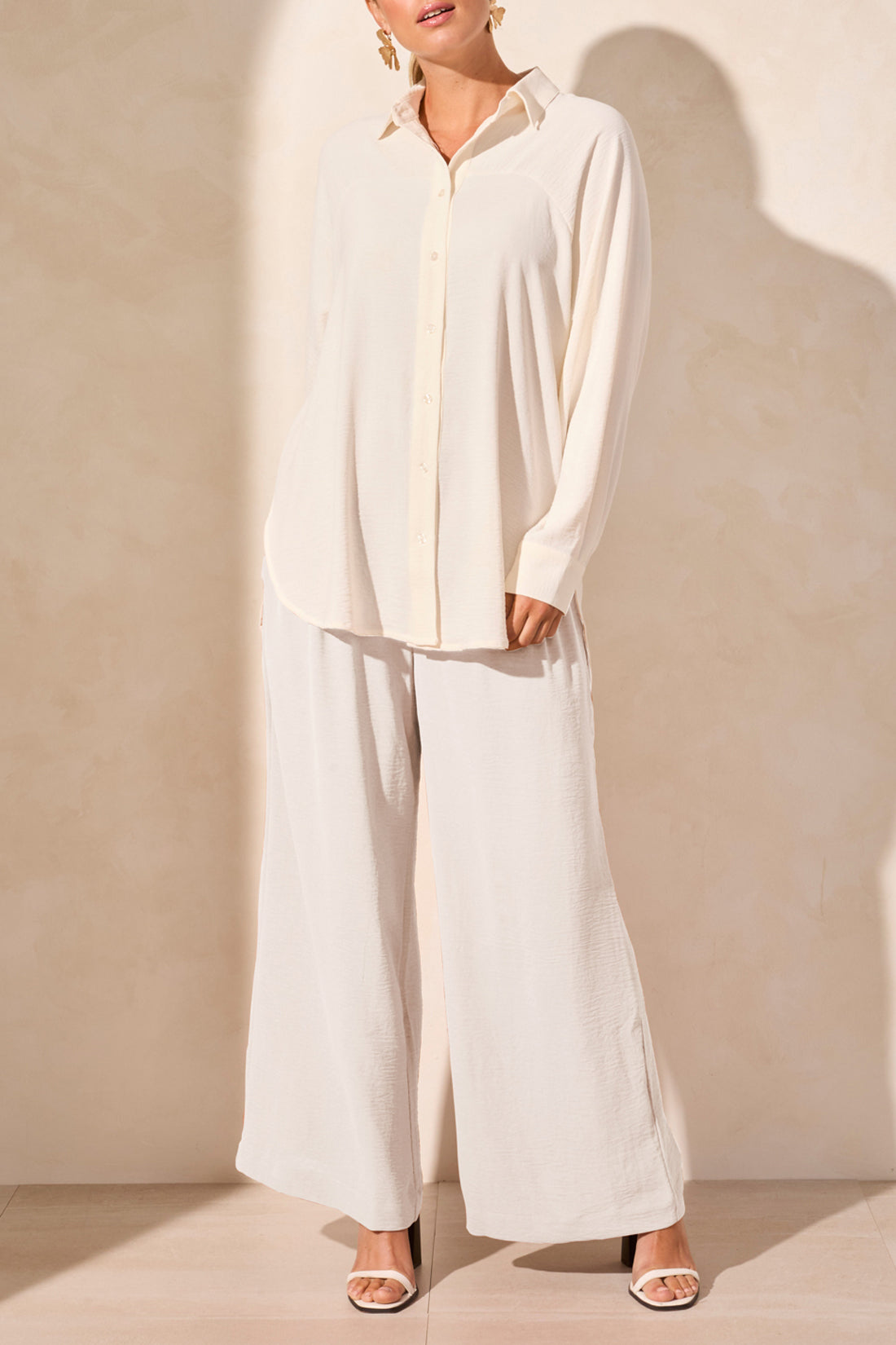 A person wearing the Tribal FLOWY RAGLAN SLEEVE SHIRT in brown, paired with loose-fitting pants, stands against a plain light-colored background.