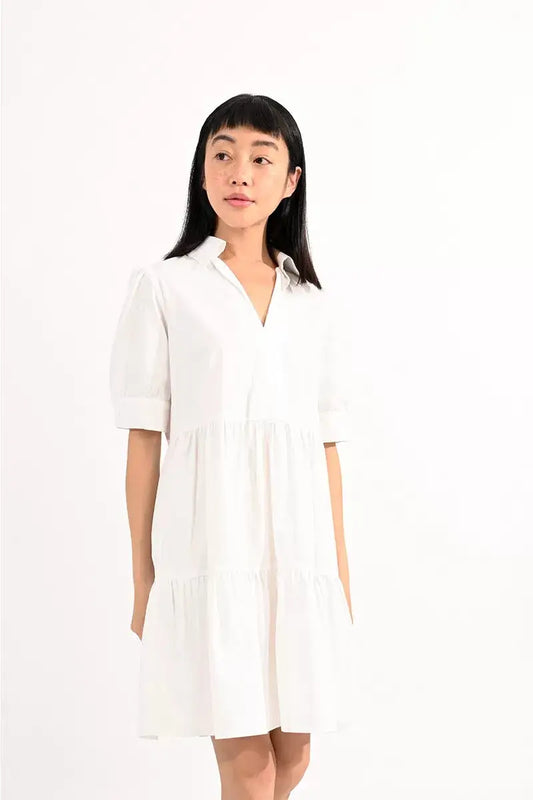 A woman in a white Elbow Sleeve V Neck Dress from Molly Bracken.