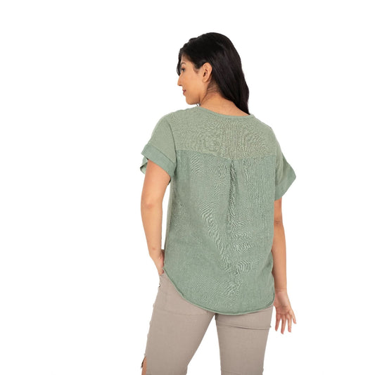 A person smiles while wearing the M Made In Italy V Neck Woven Top in green, paired with beige shorts against a white background.