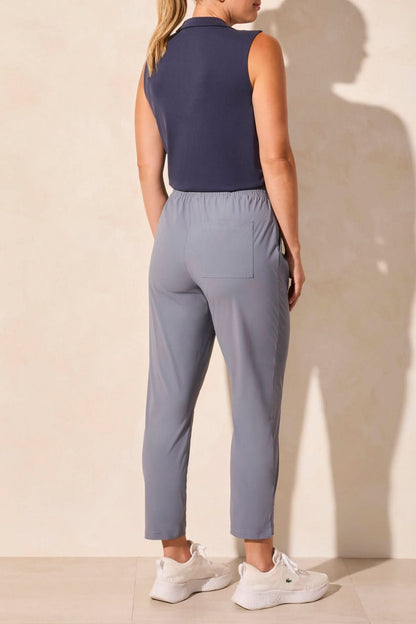 Model wears light gray Tribal PULL-ON SPORT CAPRIS with white sneakers, standing against a plain light background with hands in pockets.