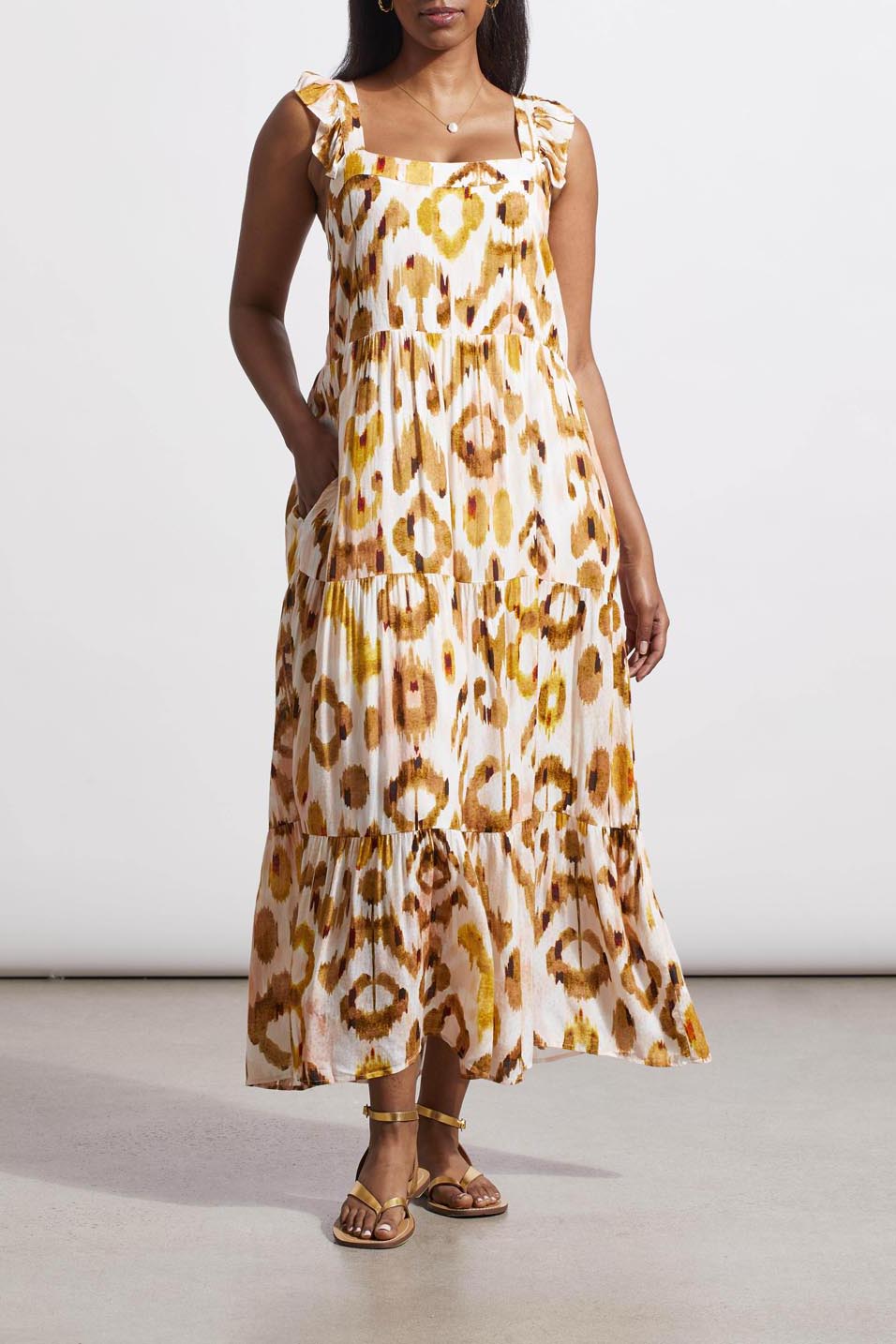 Woman in a versatile tie-dye patterned Tribal Flutter Strap Maxi Dress and brown sandals standing against a neutral background.