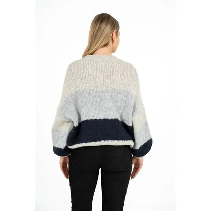 A person is wearing the M Made In Italy Oversized Colorblock Knit Sweater, featuring sections of light and dark gray, and standing against a plain white background.