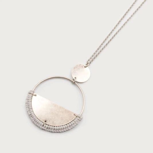 Metal Ring Pendant Necklace by Caracol, showcasing a circular pendant with a half-moon design and a small round charm, elegantly hanging from a fine long chain.