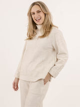 A woman wearing the Nile Pullover by Shannon Passero, a white jacquard top with artisanal details.