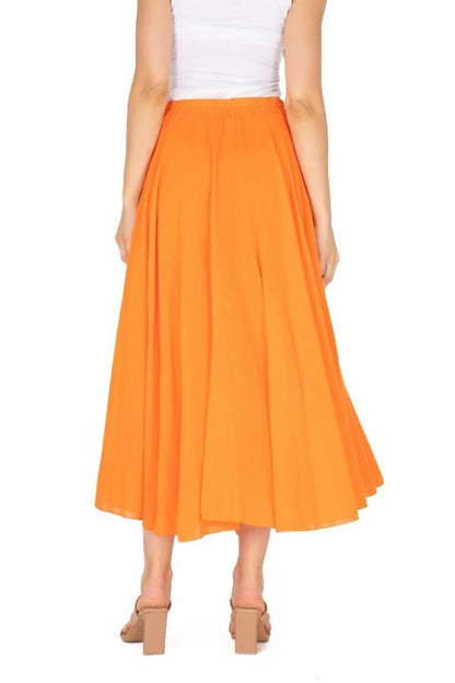 The sentence could be rewritten as: Rear view of a person in a white top and stylish M Made In Italy Tangerine Woven Skirt, paired with beige high heels.