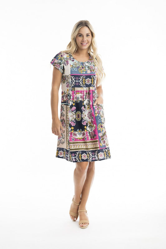 A woman with long blonde hair faces away, modeling the Orientique Sotavento Bib Dress with Pockets and beige shoes—an ideal addition to your summer wardrobe, shown against a white background.