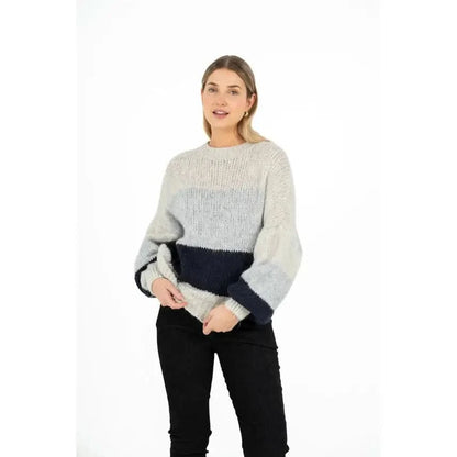 A person is wearing the M Made In Italy Oversized Colorblock Knit Sweater, featuring sections of light and dark gray, and standing against a plain white background.