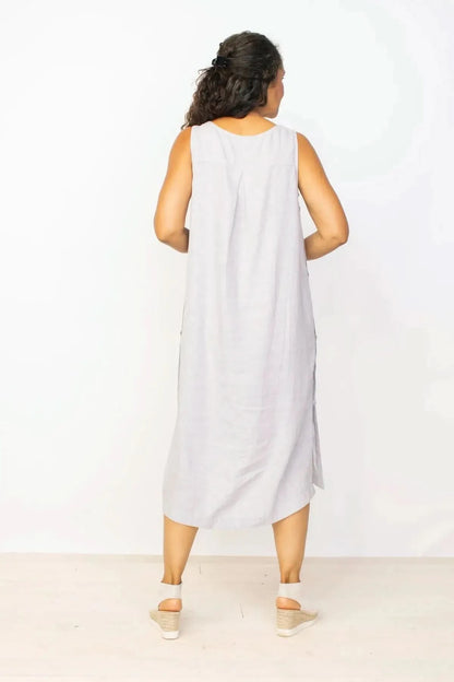 Woman smiling and posing in a Habitat Side Button Detail Sleeveless Dress in gray against a white background.