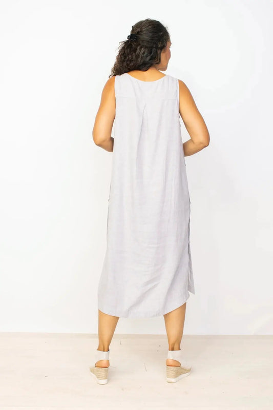 Woman smiling and posing in a Habitat Side Button Detail Sleeveless Dress in gray against a white background.