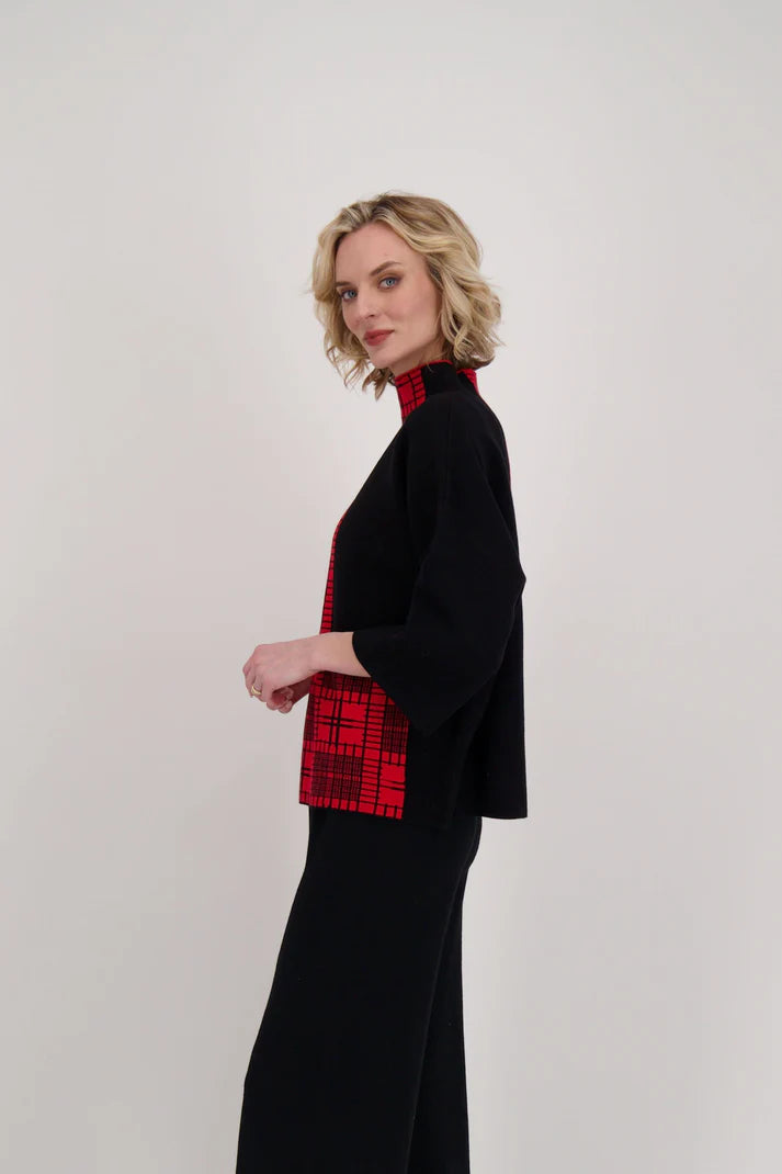 A person wearing the Gabby Isabella Two Tone Mock Neck Knit Top with black pants stands against a plain white background.