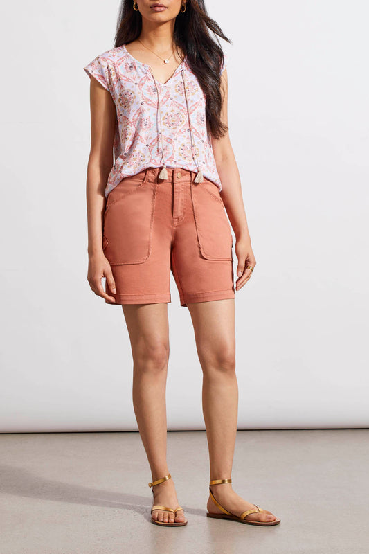 A woman in Dark Cyder Patch Pocket Girlfriend Shorts by Tribal is standing in front of a white wall.