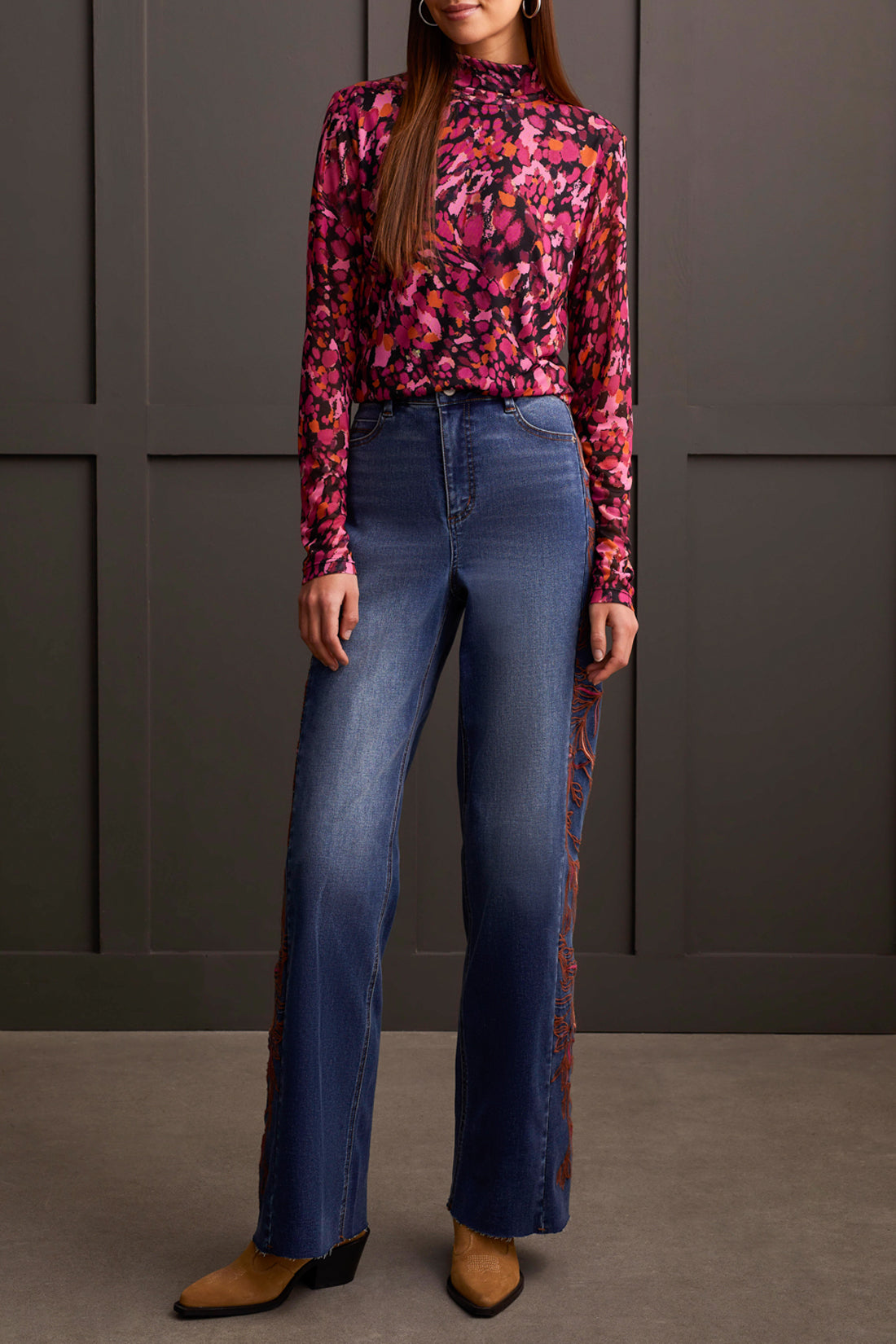 A person wearing a cozy Tribal Turtleneck Lined Top and high-waisted wide-leg jeans stands in front of a paneled wall. Brown shoes are visible at the bottom of the jeans, completing this perfect winter wardrobe look.