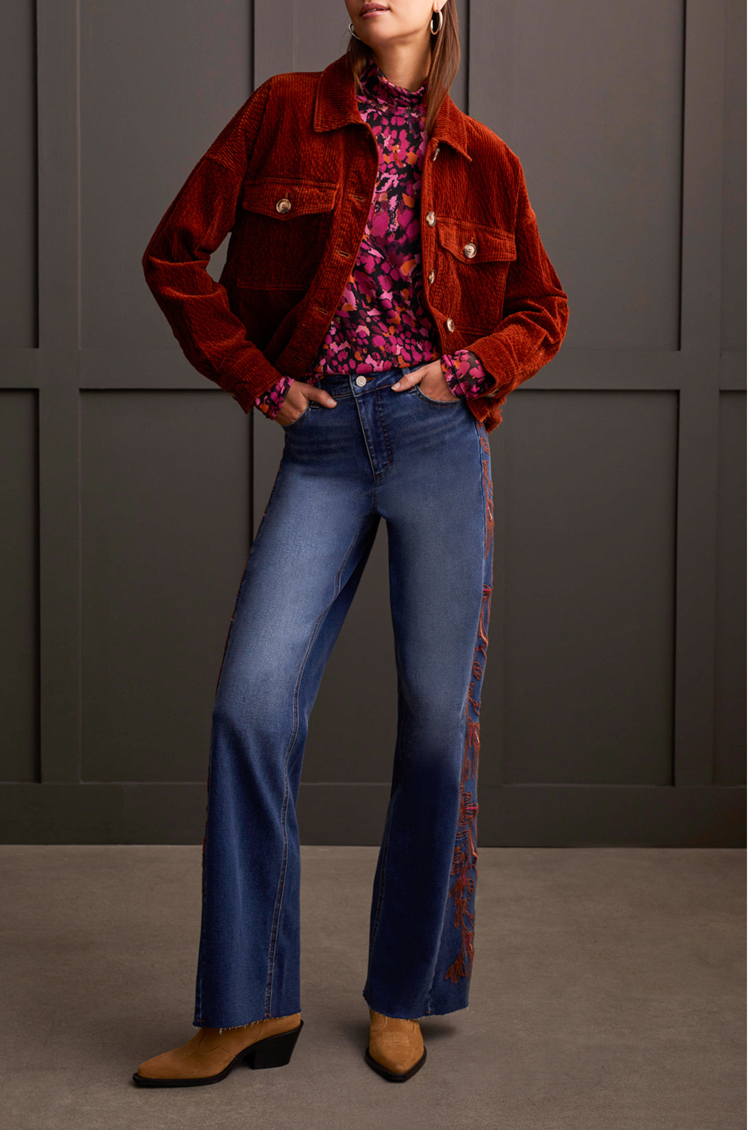 A person wearing a cozy Tribal Turtleneck Lined Top and high-waisted wide-leg jeans stands in front of a paneled wall. Brown shoes are visible at the bottom of the jeans, completing this perfect winter wardrobe look.
