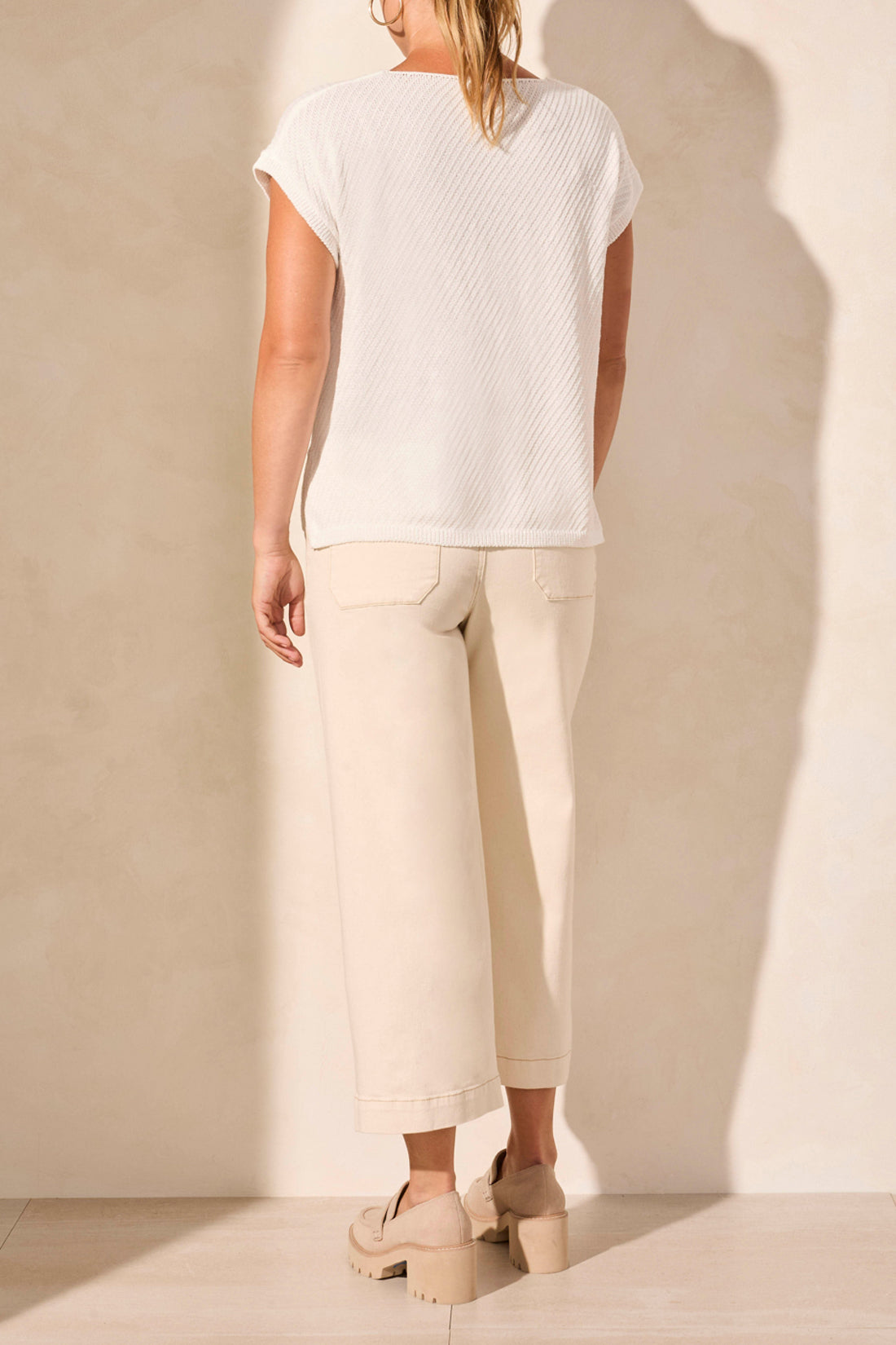 A person in a Tribal SLIT V NECK SWEATER, beige wide-leg pants, and loafers embodies ultimate coziness on a neutral backdrop.