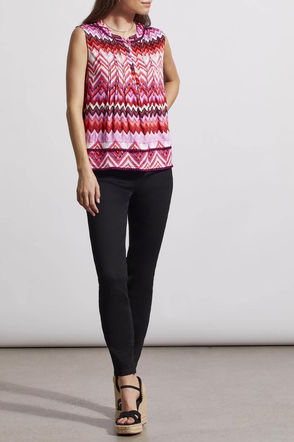 Woman wearing a trendy sleeveless Tribal top with a pink and white zigzag pattern.