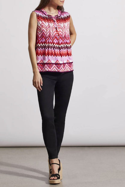 Woman wearing a trendy sleeveless Tribal top with a pink and white zigzag pattern.