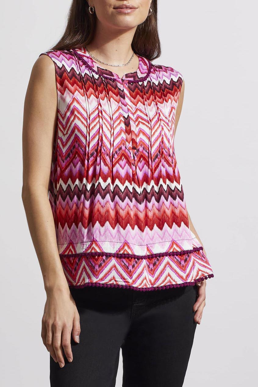 Woman wearing a trendy sleeveless Tribal top with a pink and white zigzag pattern.