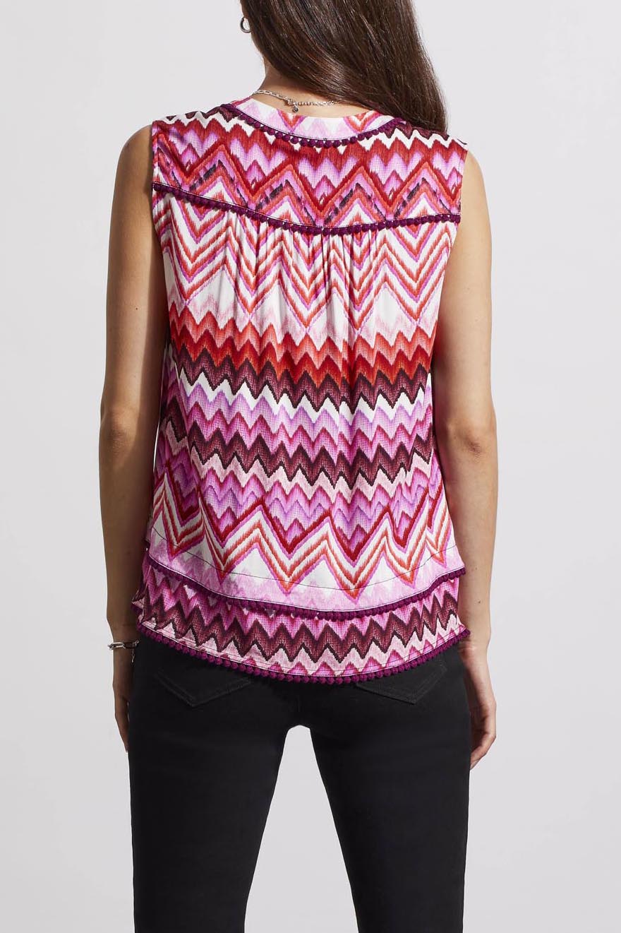 Woman wearing a trendy sleeveless Tribal top with a pink and white zigzag pattern.