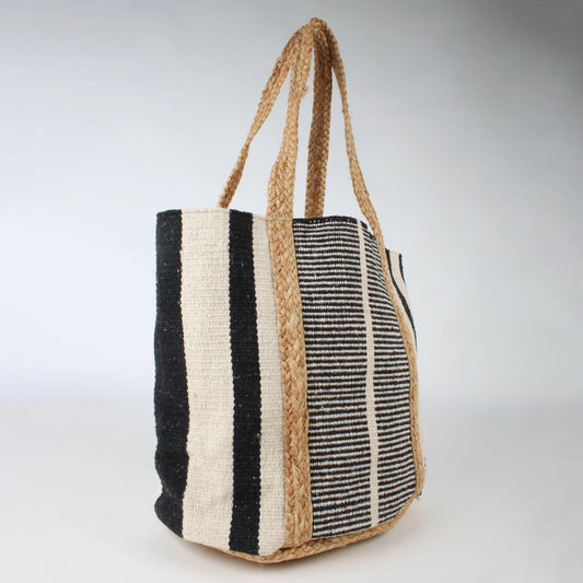 The Co-Lab Santa Barbara Stripe Beach Tote, with vertical black and cream stripes and braided handles, is shown on a light background—a chic accessory ideal for your beach outings.