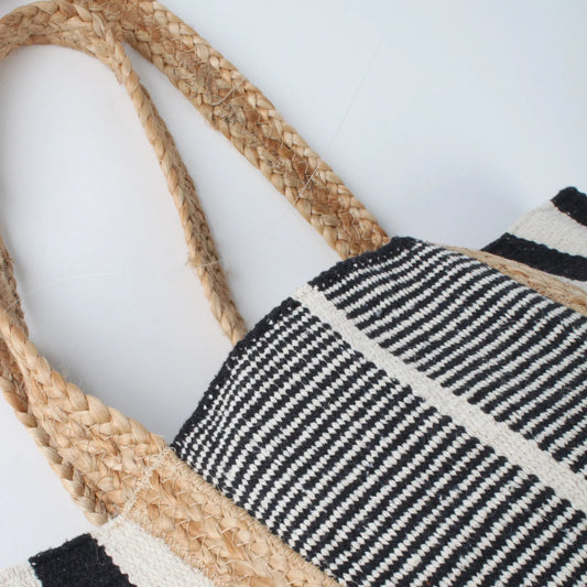 Close-up of the Co-Lab Santa Barbara Stripe Beach Tote, featuring thick braided straw handles and a black and white striped body—a stylish accessory for beach outings.
