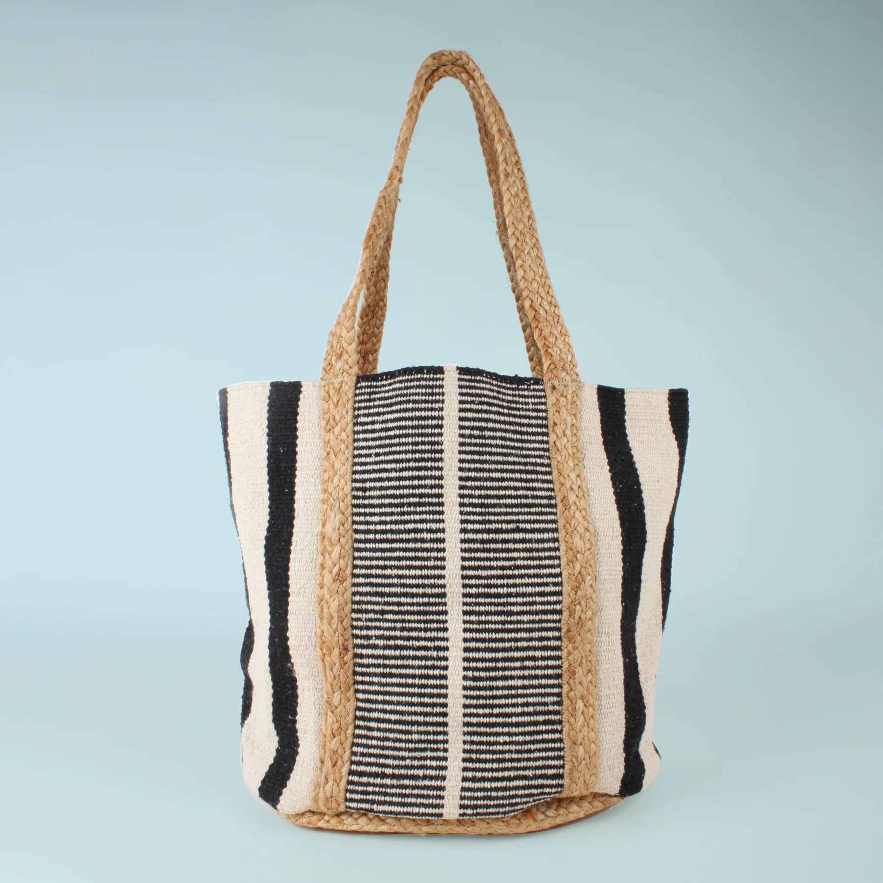 Close-up of the Co-Lab Santa Barbara Stripe Beach Tote, featuring thick braided straw handles and a black and white striped body—a stylish accessory for beach outings.