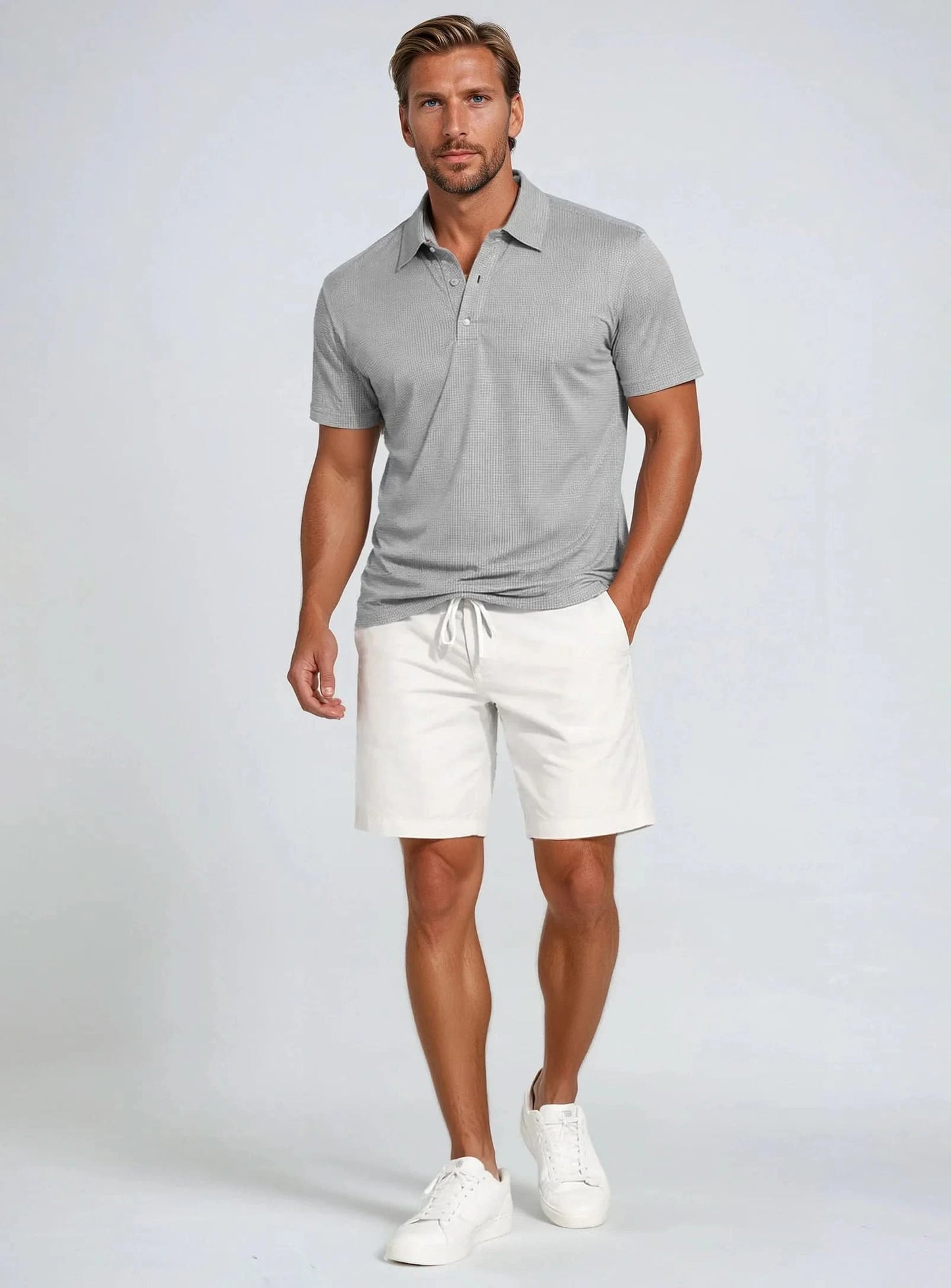 The Point Zero Men's Dry-X Waffle Polo is a gray short-sleeve polo with subtle horizontal stripes, a buttoned placket, and collar—ideal as a moisture-wicking shirt for all-day comfort and style.