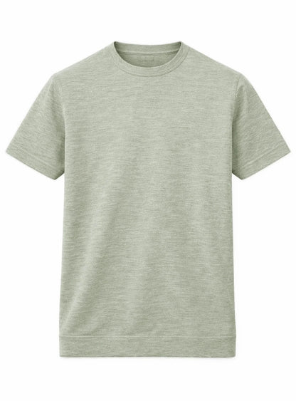 A man showcases effortless summer style in a Point Zero Mens Short Sleeve Active Top, paired with gray pants and white sneakers, standing against a plain background with one hand in his pocket.