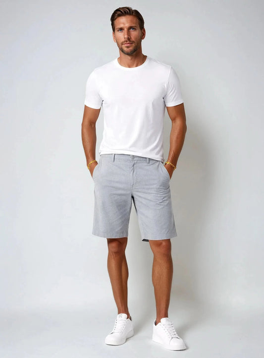 Point Zero Mens Super Flex Bermuda Short in light grey offers comfort with stretch fabric, side pockets, a left zippered pocket, button closure, and a red Point Zero tag on the waistband.