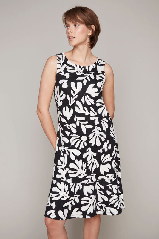 A person is wearing a Carre Noir Leaf Print Sleeveless Dress, showcasing its nature-inspired design with a subtle leaf print, while posing against a plain backdrop.