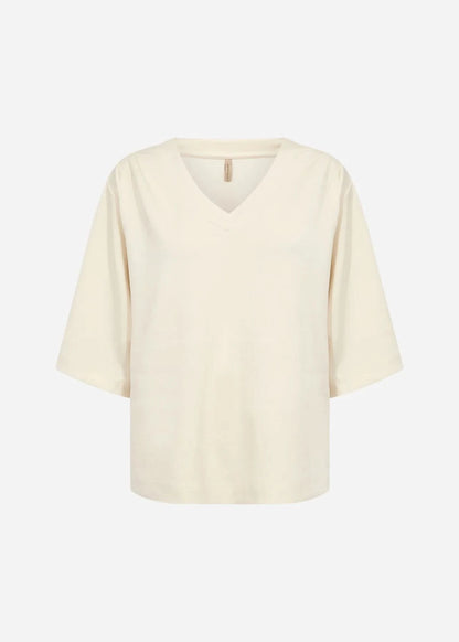 A woman with long blonde hair wears the Soya Concepts Banu Top, its elegant silhouette highlighted as she stands against a plain white background.