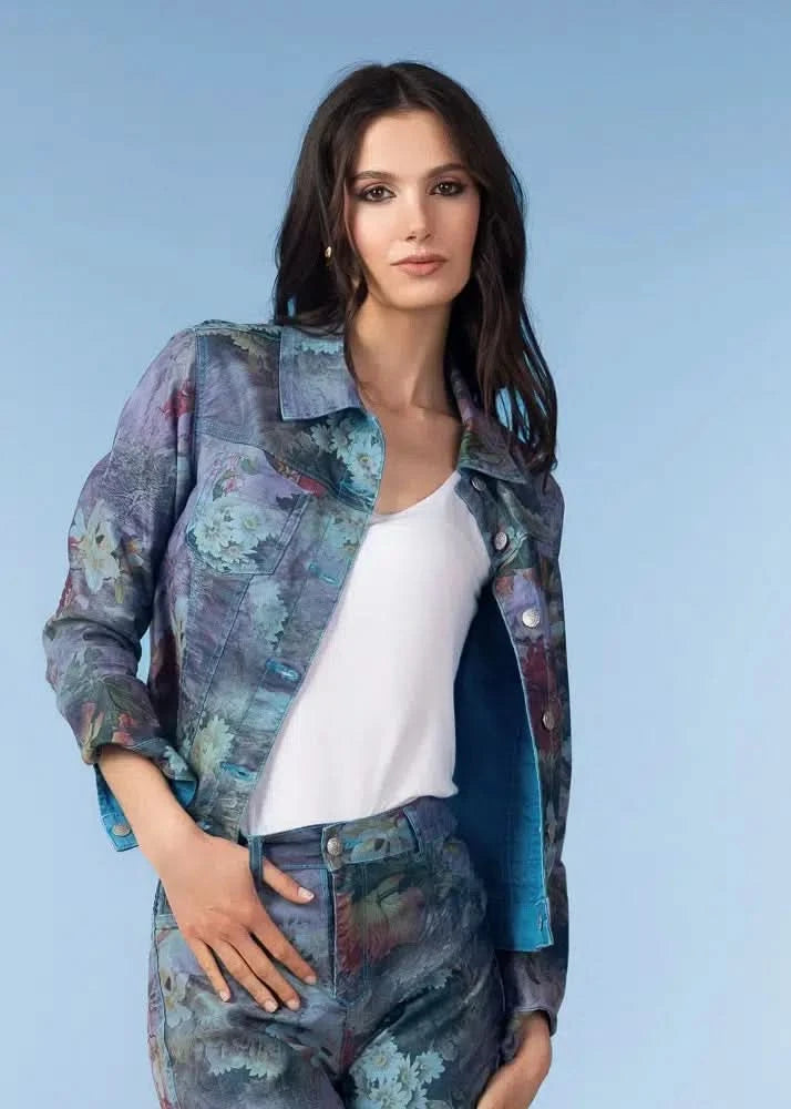 A woman models the Alison Sheri Garden Reversible Jacket with matching pants over a white top, standing against a plain blue background.