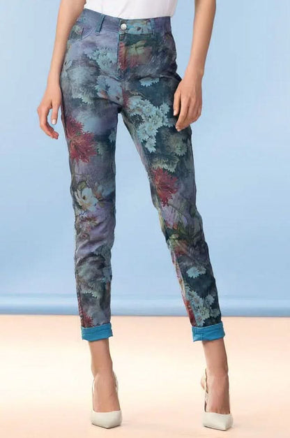 A person wearing Alison Sheri Garden Reversible Jeans with blue floral print, white heels, and a white top stands against a light blue background.