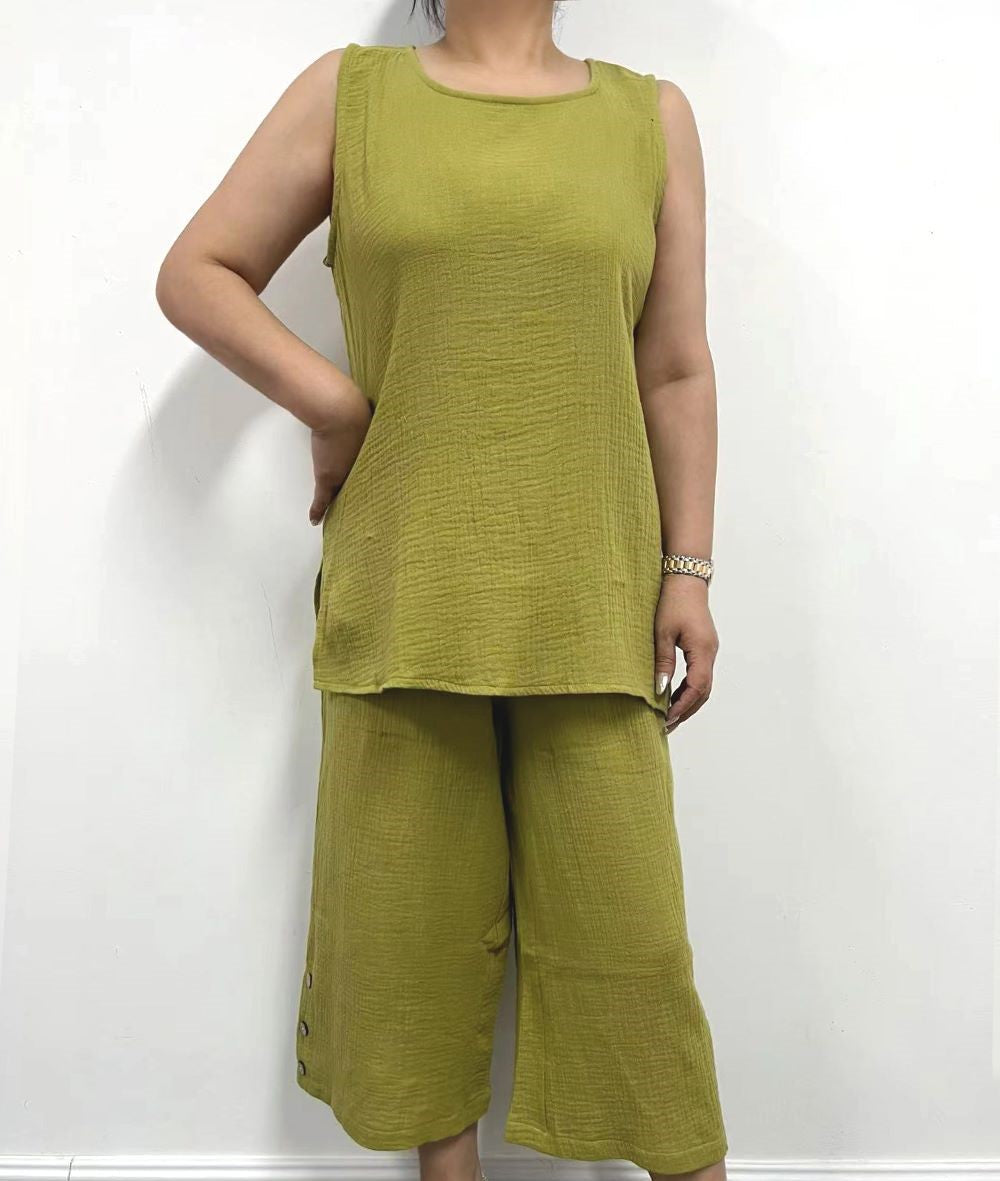 Person dressed in a sleeveless Gauze Top by Creation and matching green pants, standing against a plain white background.