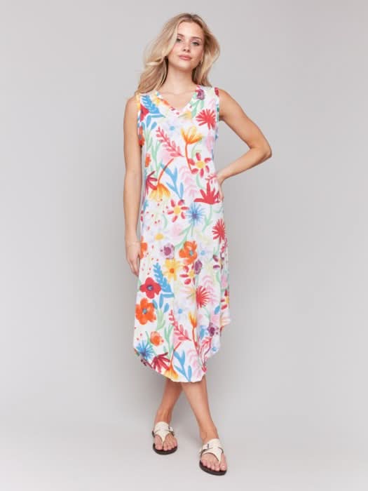 A woman wears the Charlie B Floral Printed Sleeveless Cotton Dress with white sandals against a plain light background—ideal for summer events.