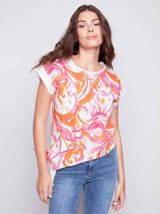 Woman posing in a high-quality Charlie B Printed Linen Knit Combo Top and white pants against a gray background.