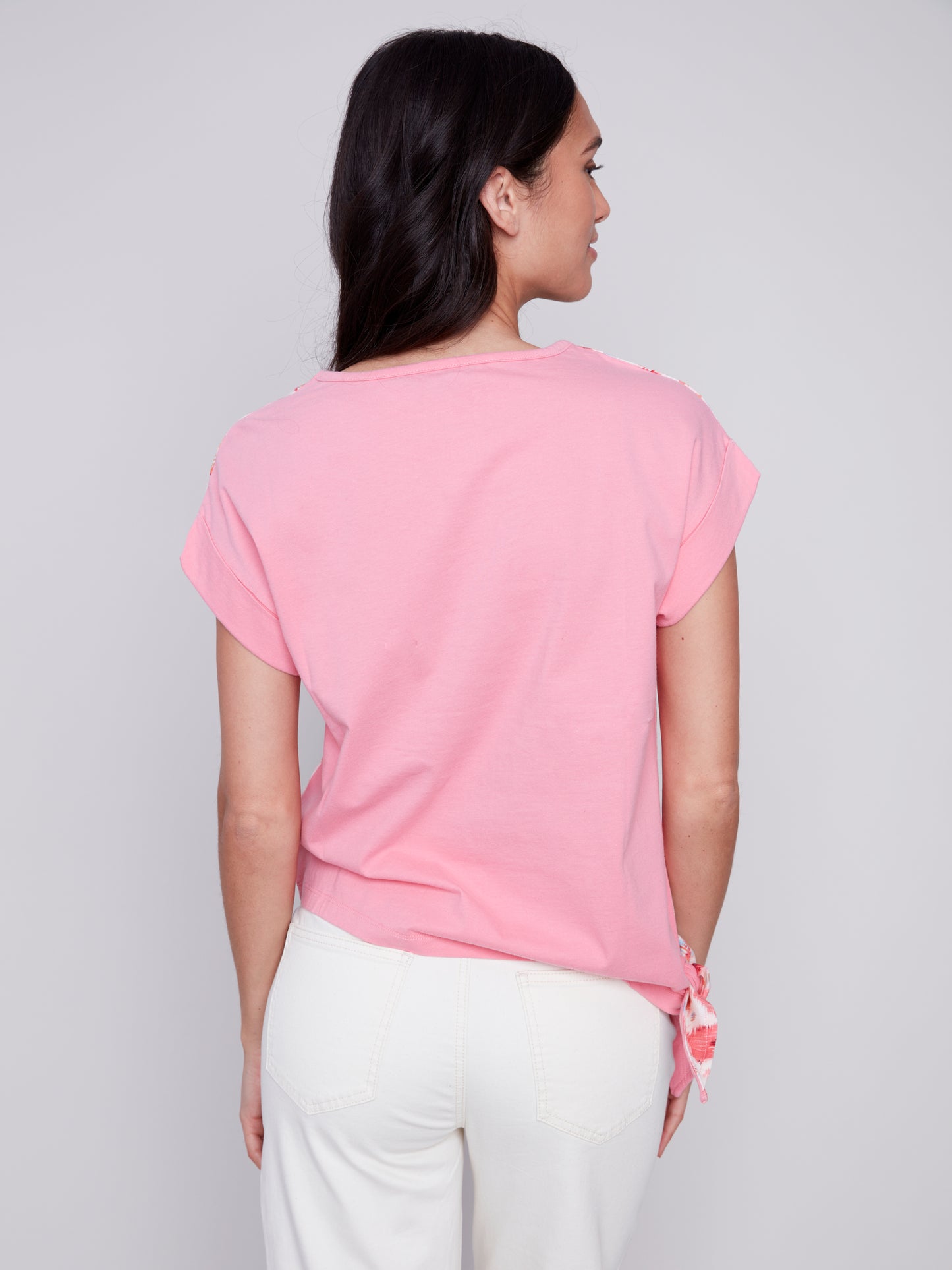 Woman posing in a high-quality Charlie B Printed Linen Knit Combo Top and white pants against a gray background.