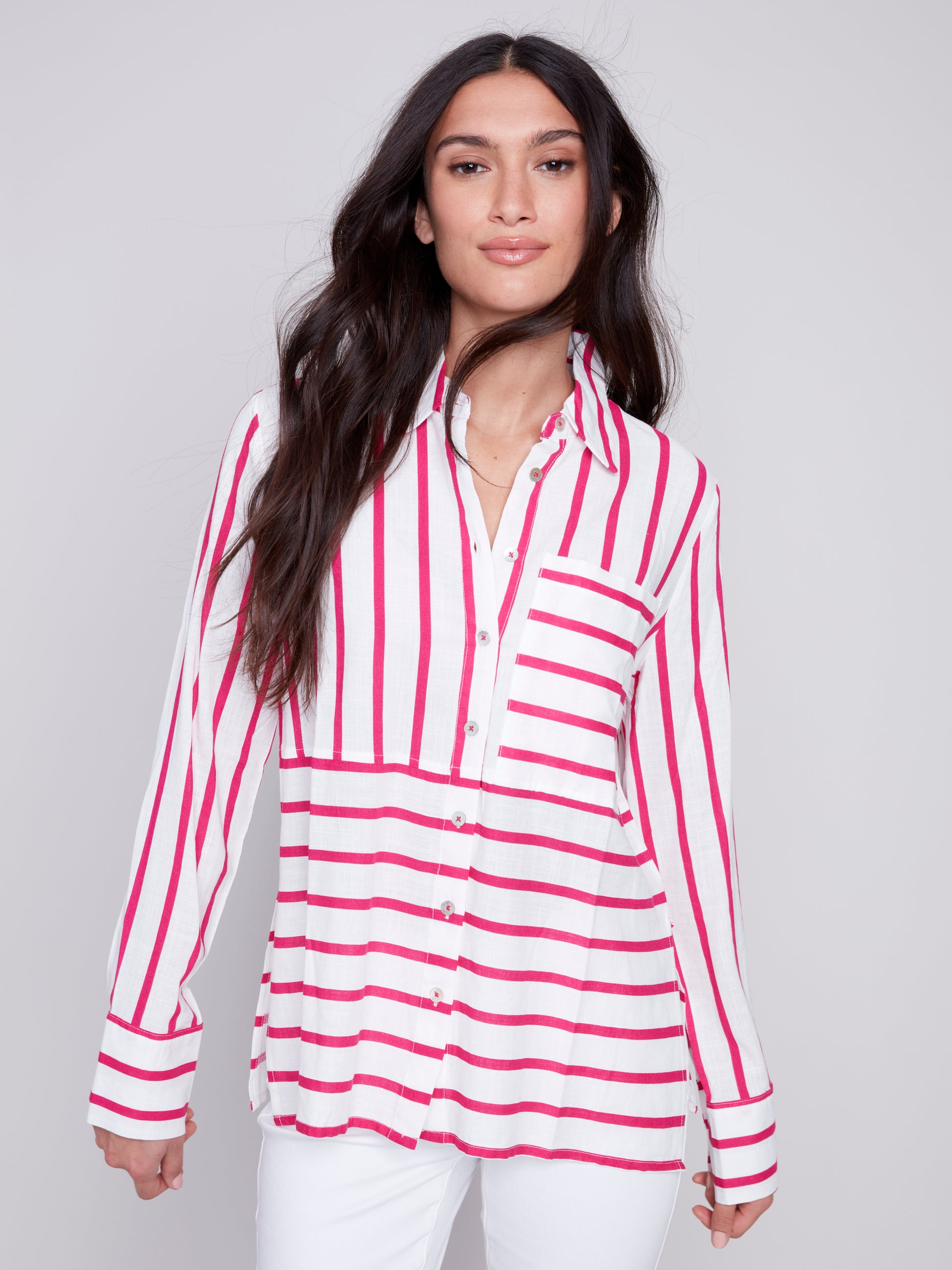 Woman wearing a Charlie B Lined Blend Striped 3/4 Button Top with white pants posing against a gray background.