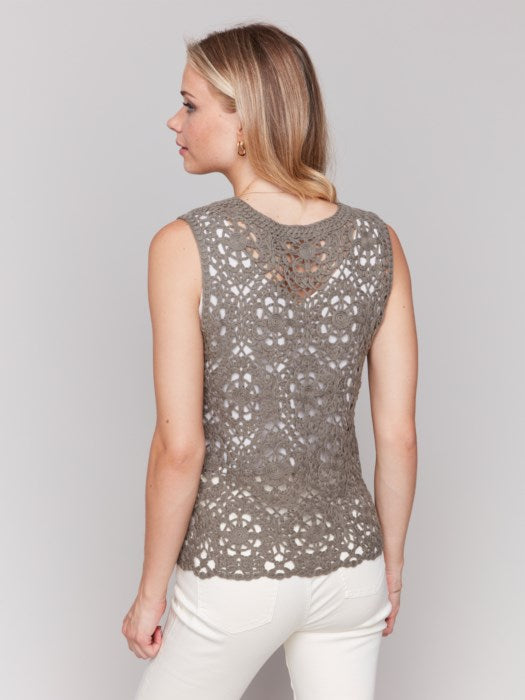 Wearing the Sleeveless Floral Cotton Crochet Top by Charlie B with white pants, the person stands gracefully against a neutral background.