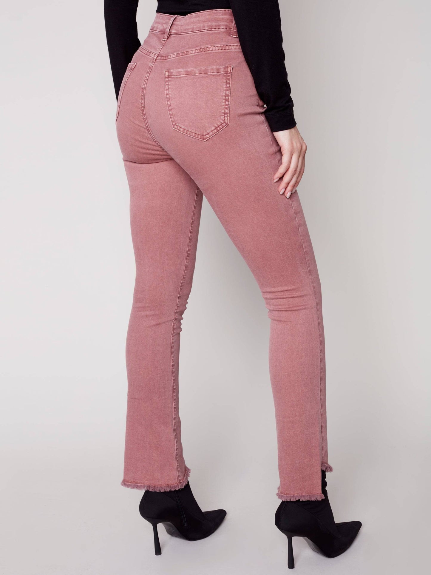 A woman in Charlie B's asymmetrical hem bootcut jeans and black Chelsea boots creates a flattering look.
