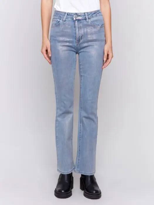 A person wearing Charlie B Foiled Bootcut Jeans and black shoes is facing away from the camera.