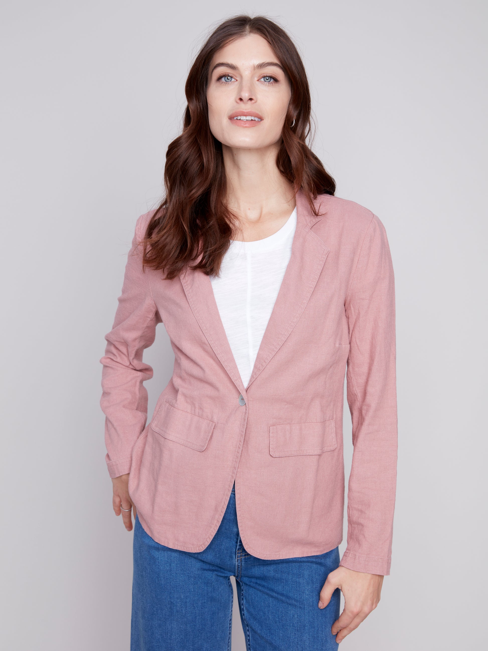 The model is wearing a pink Charlie B lined button-up blazer, a wardrobe staple that is made with high-quality materials.