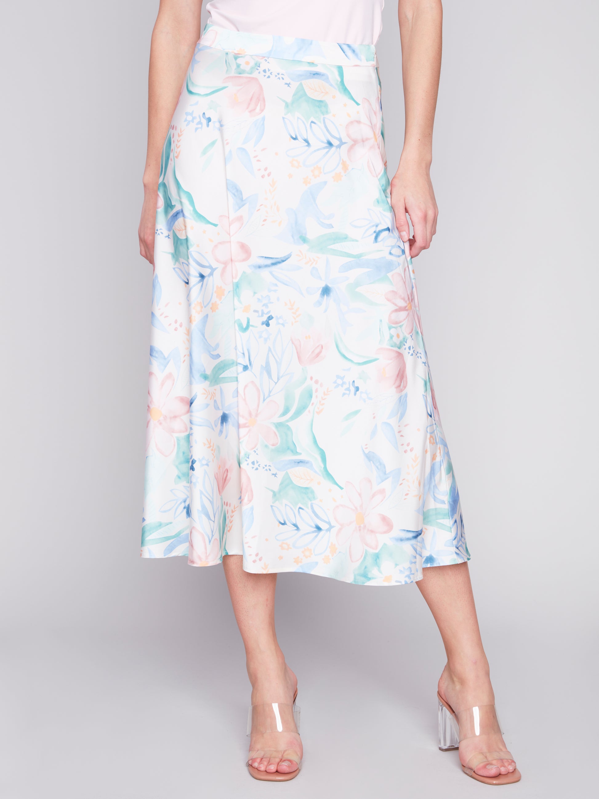 Woman posing in a sleeveless top and Charlie B Petal Flow Long Satin Skirt.