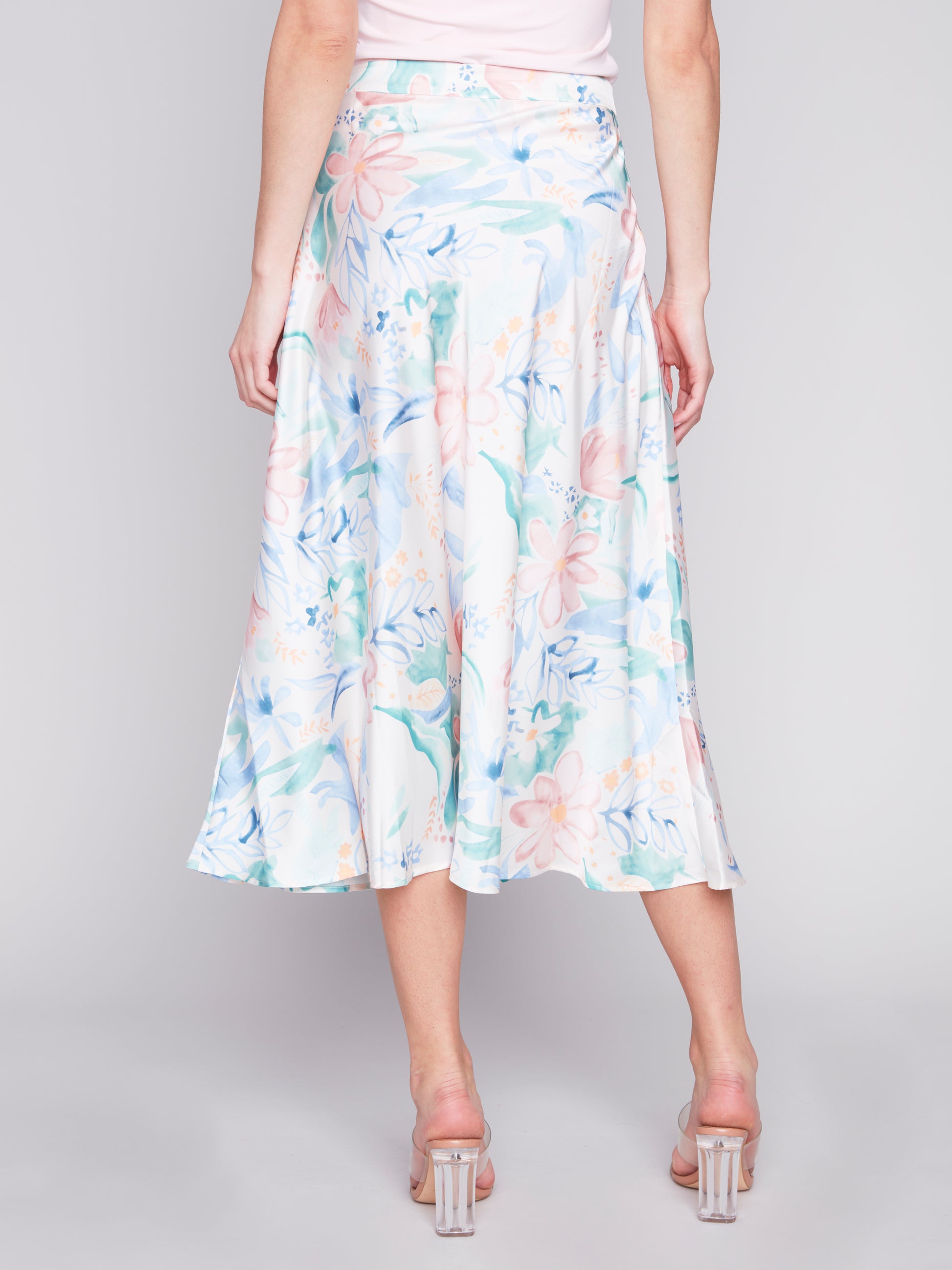 Woman posing in a sleeveless top and Charlie B Petal Flow Long Satin Skirt.