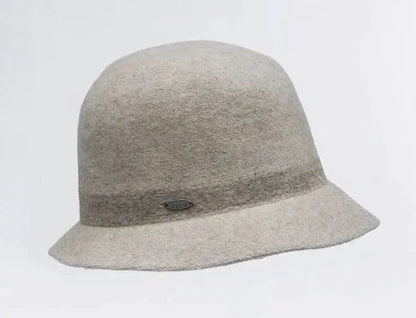 A woman wearing a black puffer jacket and pants, sporting an iconic Claude - Small Bell Hat from Canadian Hat, from Montreal.