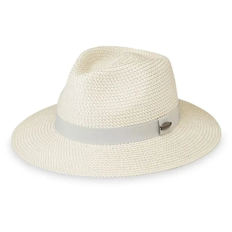 The Wallaroo Charlie Fedora is a light-colored woven straw hat featuring a wide brim and a light gray band, designed to be easily packable—perfect for travel.