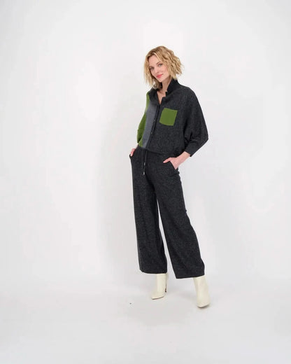 A woman wearing a grey jumpsuit and green boots made of stretchy knit fabric, Gabby Isabella's Color Block Knit Sweater Pullover Top.