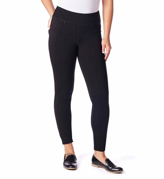 A person stands against a plain background wearing a white t-shirt, black Ricki Skinny Leggings by Jag with a mid-rise waistline, and black slip-on shoes.