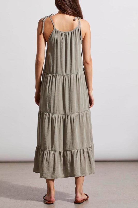A woman standing in a neutral pose wearing a Tribal lined sleeveless dress with adjustable straps and brown sandals.